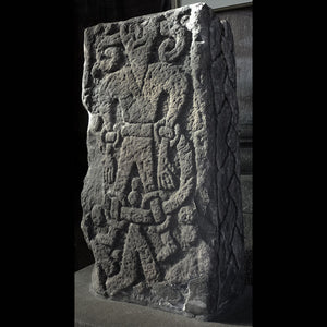 Picture taken by Karl & Ali and attributed to them. Shows the Loki stone at an angle - with an image of Viking Age art carved into a stone of a man bound by ropes and with curling horns.