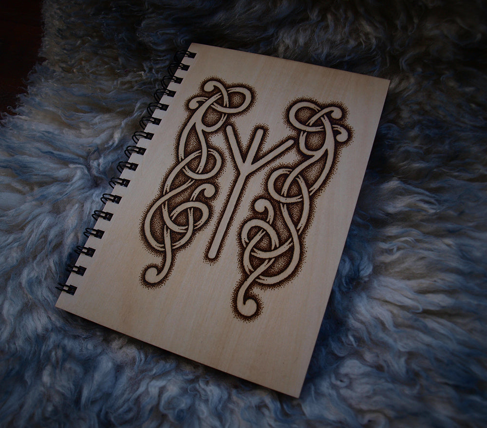 Photo of wood covered notebook endorsed with a Viking style pyrography design