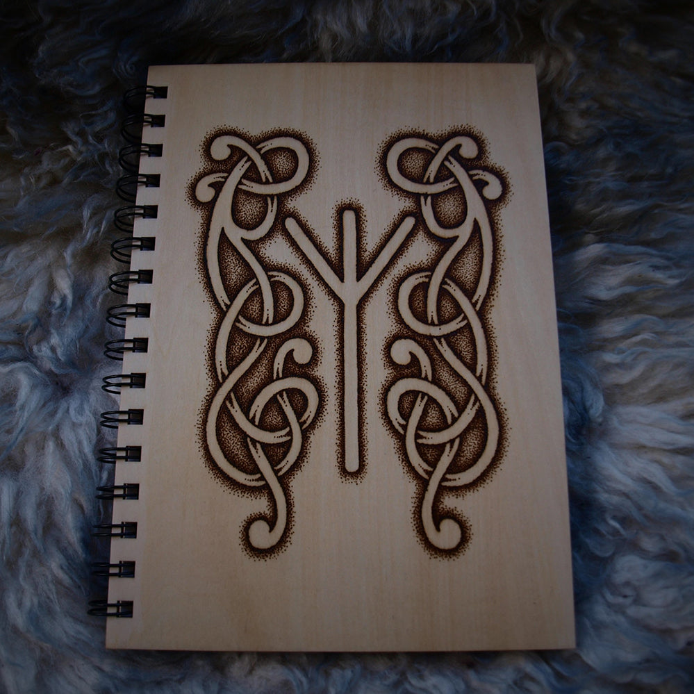 Photo of wood covered notebook endorsed with a Nordic style pyrography design