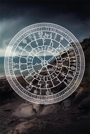 An image of a runic wheel with symbols of the year surrounding it, in white and printed overtop of a photograph of a rocky seashore.